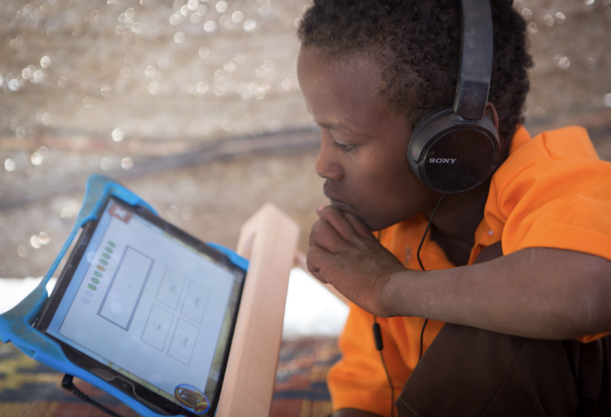 Child learning on a tablet with headphones